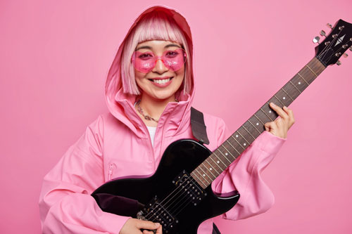 Woman with guitar and pink hair